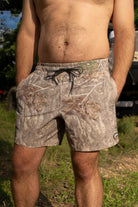 Person wearing camouflage shorts in an outdoor setting
