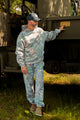 Man in camouflage hoodie and pants outdoors.