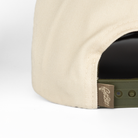 closeup of get bit logo woven label on Natural/Olive hat 